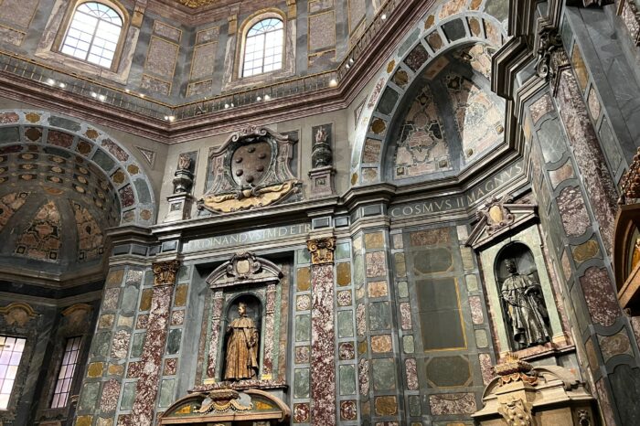 a large clock mounted to the side of Medici Chapel