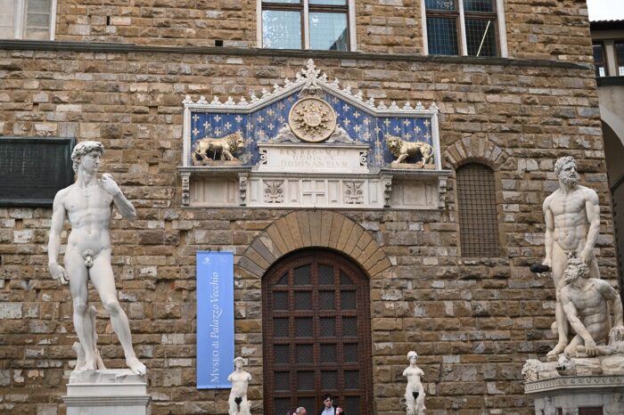 a statue of a person standing in front of a brick building