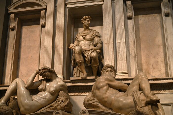 a statue of a person sitting on a bench