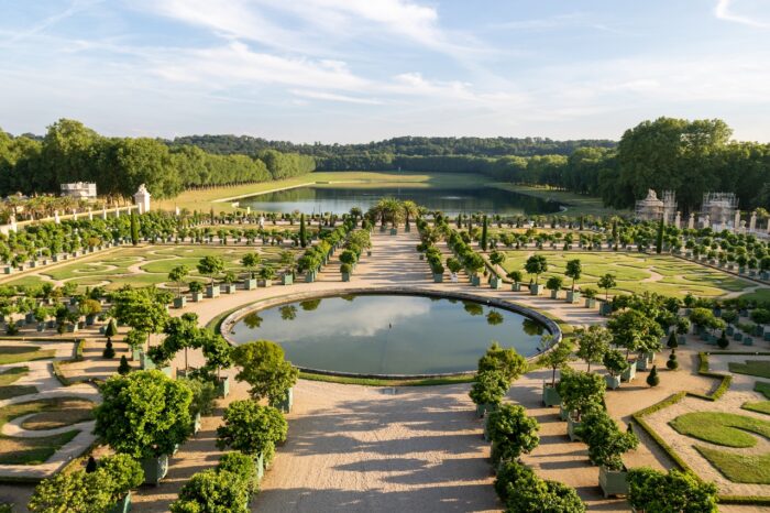 Palace of Versailles over a river in a garden