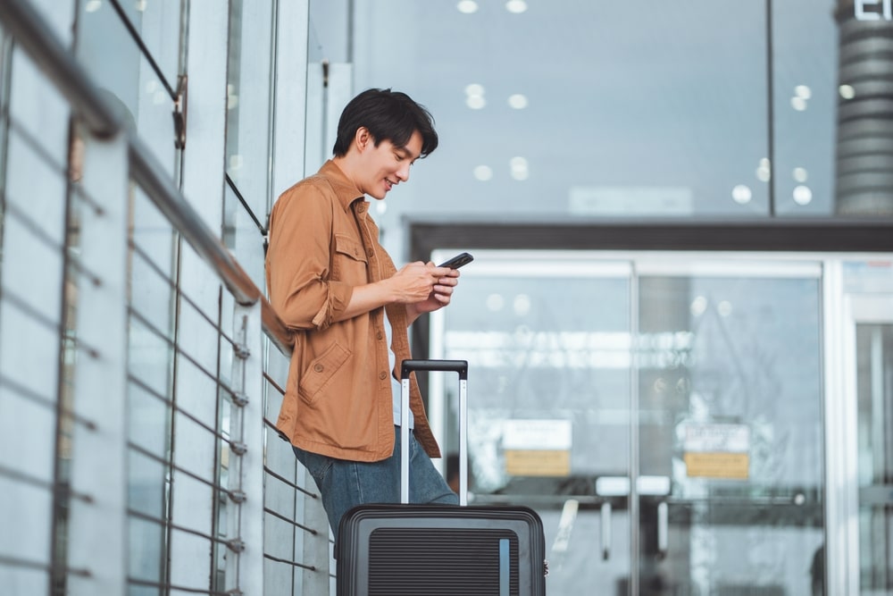 A man browsing a phone for essential mobile apps