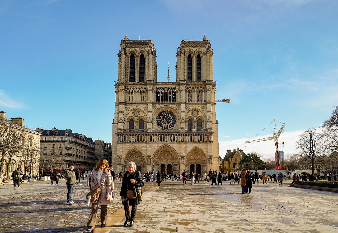 Notre Dame Cathedral west facade with visitors in the forecourt, Paris