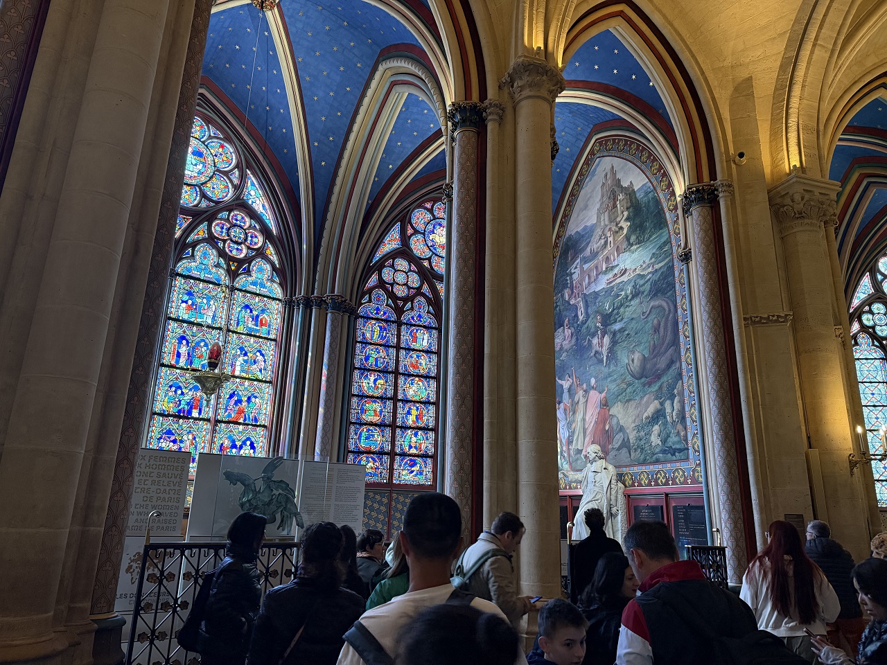 Interior of Notre Dame Cathedral Paris showing Gothic stained glass windows and vaulted ceiling