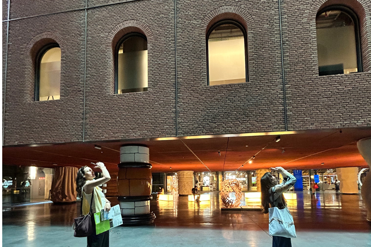 isitors photographing the industrial brick facade and columns inside Azkuna Zentroa, Bilbao