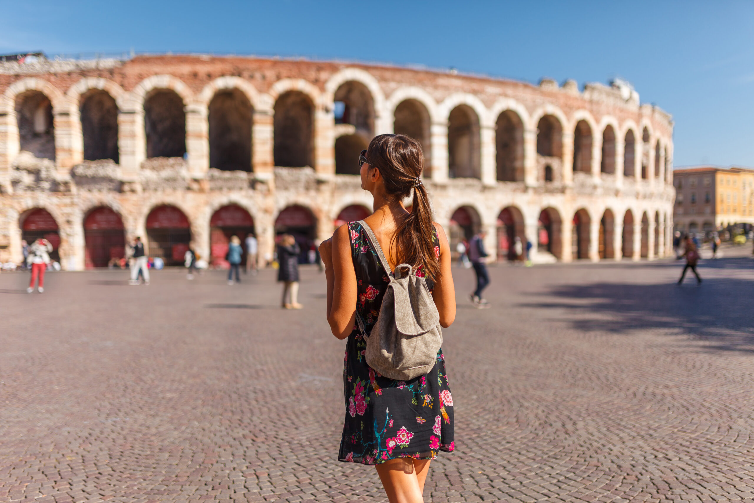 Woman walking toward the Arena di Verona amphitheater in Piazza Bra