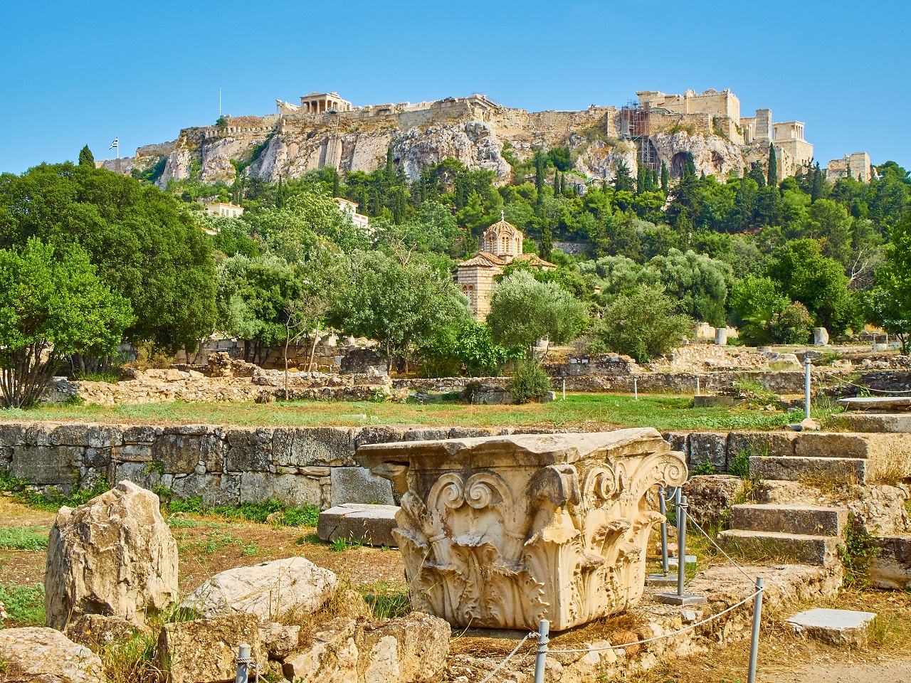 Ruins of Odeon of Agrippa, located at the Ancient Agora of Athens with Church of the Holy Apostles and the north slope of the Athenian Acropolis in background. Attica region, Greece.